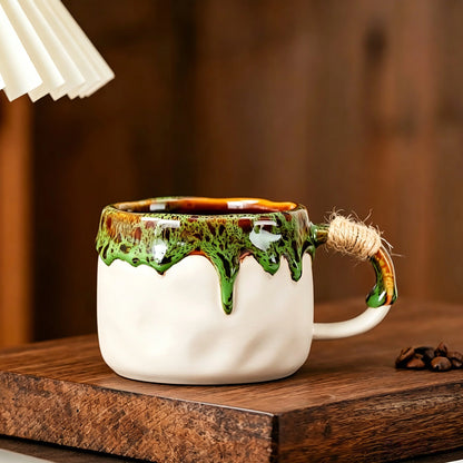 These vintage kiln‑change ceramic mugs feature unique dripping glaze rims and textured hand‑thrown bodies. The handles are wrapped with natural jute rope, adding a rustic artisanal touch. Available in multiple charming colorways, they make lovely daily coffee and tea drinking sets.
