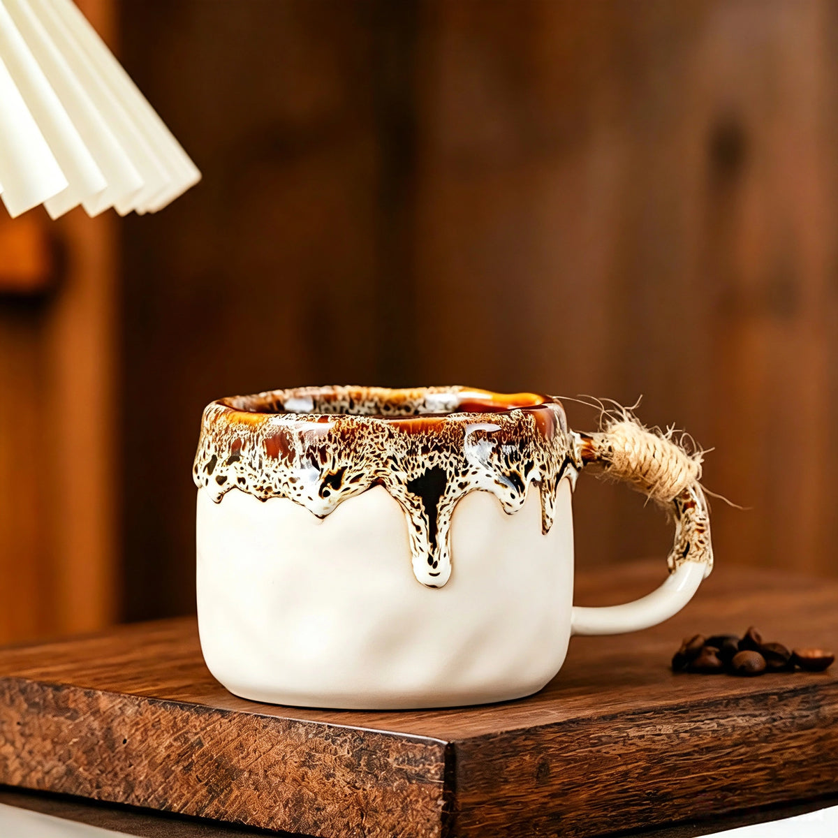 These vintage kiln‑change ceramic mugs feature unique dripping glaze rims and textured hand‑thrown bodies. The handles are wrapped with natural jute rope, adding a rustic artisanal touch. Available in multiple charming colorways, they make lovely daily coffee and tea drinking sets.