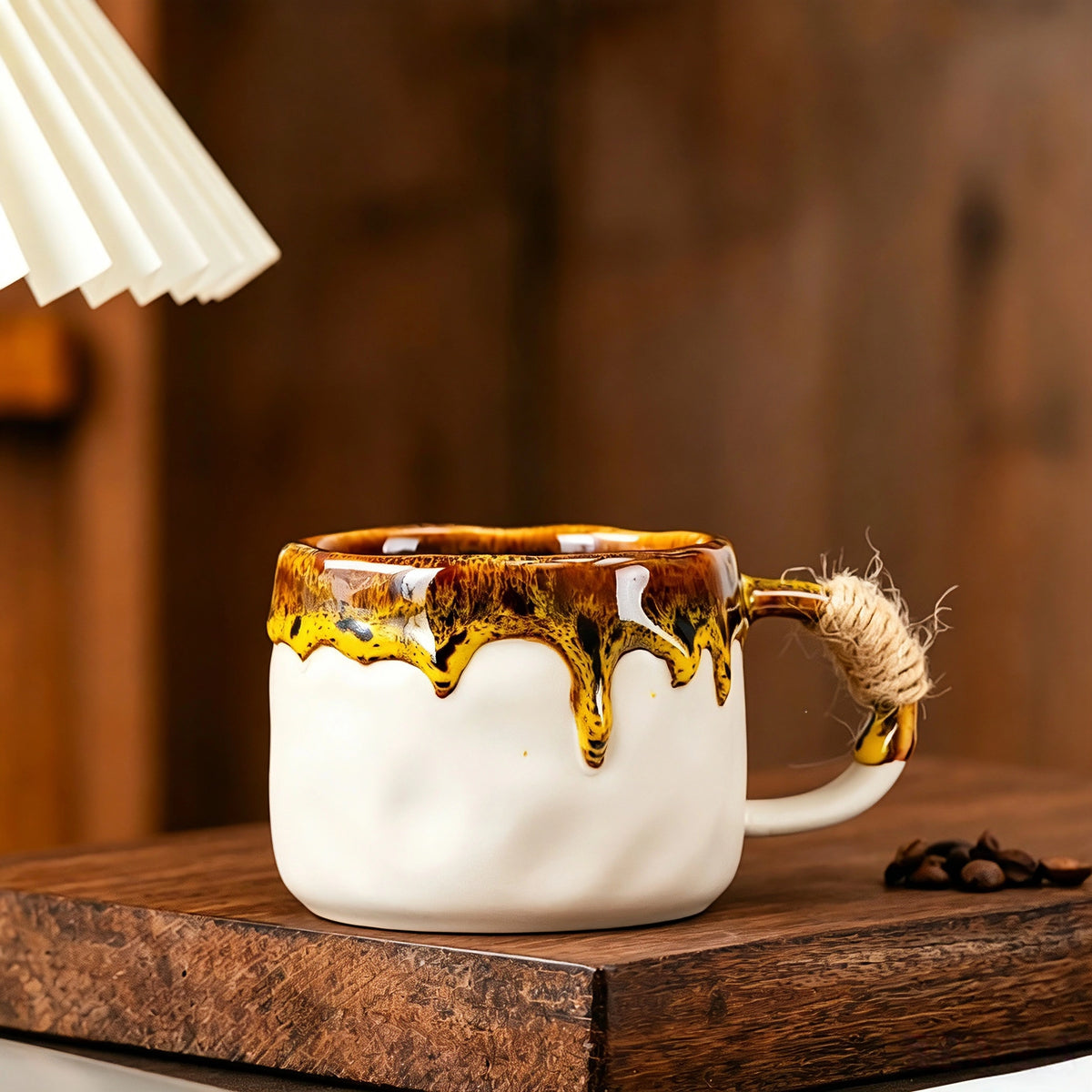 These vintage kiln‑change ceramic mugs feature unique dripping glaze rims and textured hand‑thrown bodies. The handles are wrapped with natural jute rope, adding a rustic artisanal touch. Available in multiple charming colorways, they make lovely daily coffee and tea drinking sets.