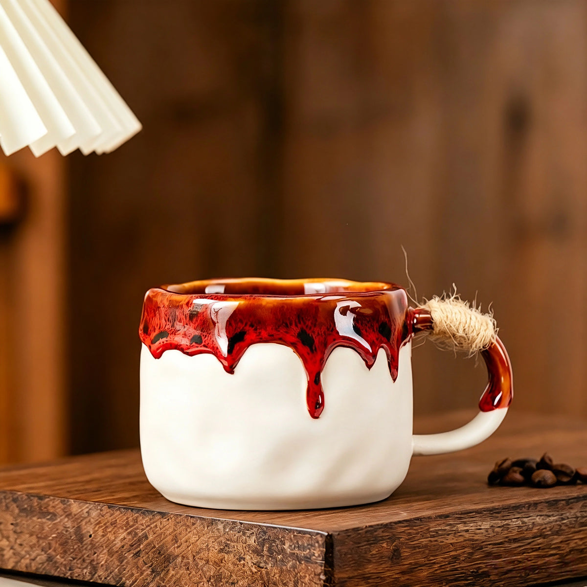 These vintage kiln‑change ceramic mugs feature unique dripping glaze rims and textured hand‑thrown bodies. The handles are wrapped with natural jute rope, adding a rustic artisanal touch. Available in multiple charming colorways, they make lovely daily coffee and tea drinking sets.